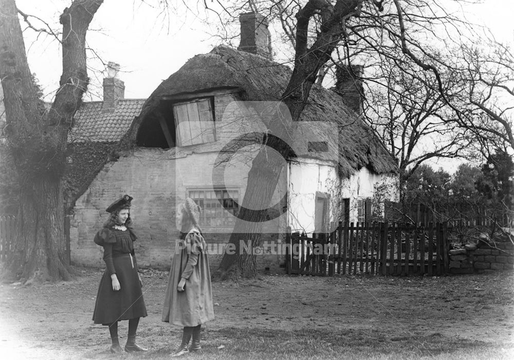 Girls in front of a thatched cottage, Clifton