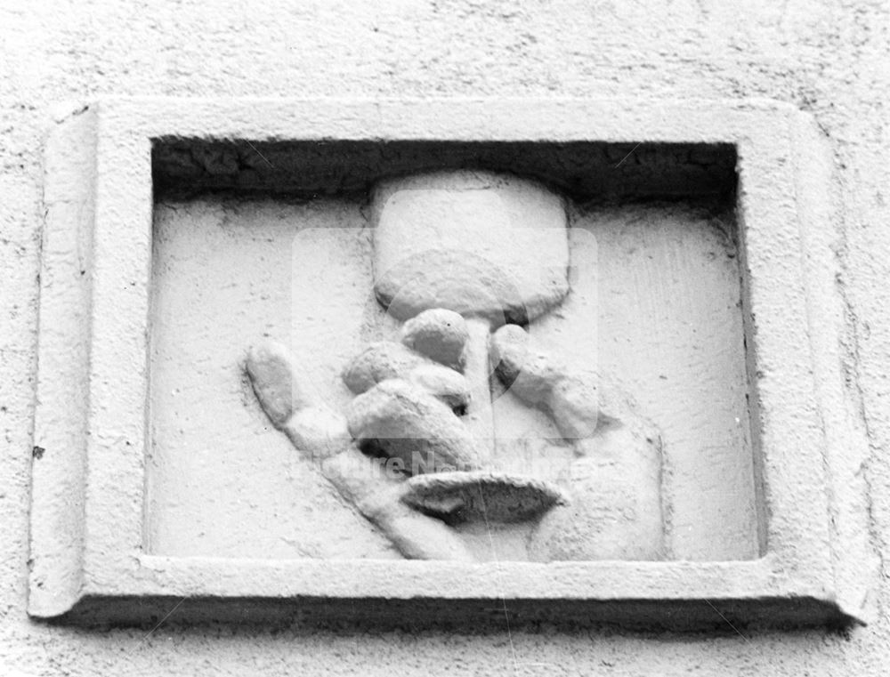 The White Lion Public House - Detail of embossed wall carving of a hand holding a glass