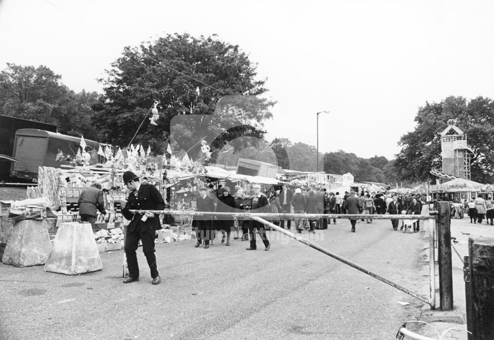 Goose Fair - Policemen at a vehicle barrier and side stalls.