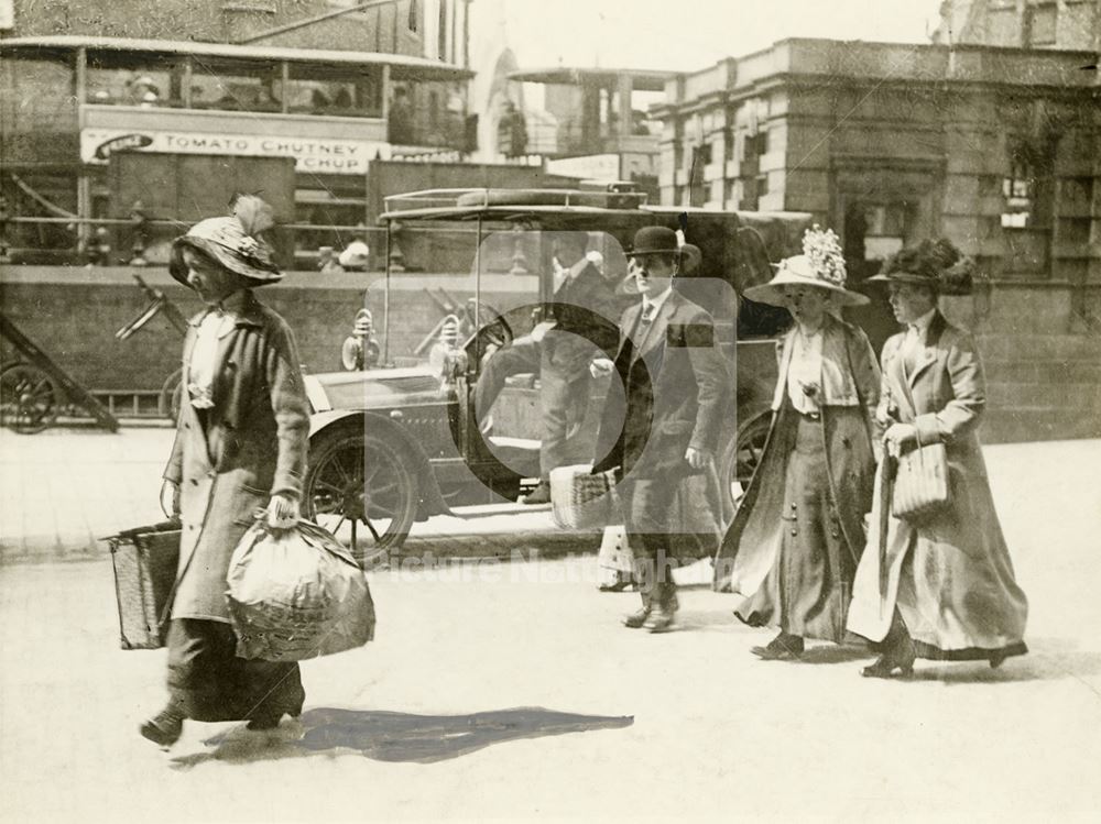 Travellers and motor cab by the exterior booking office and forecourt of Victoria Railway Station