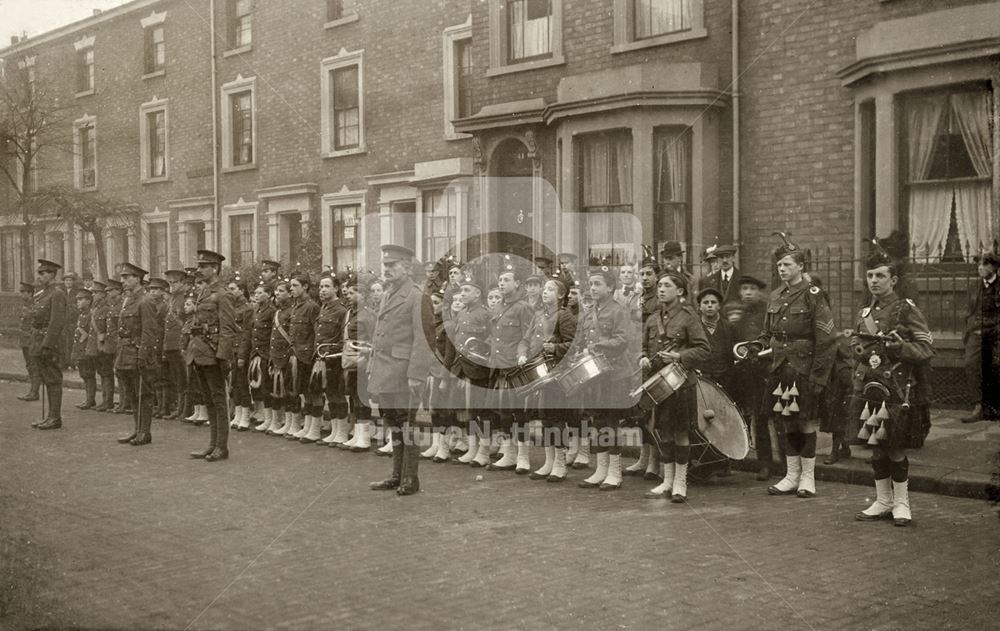 Military group of men and boys' band, on parade dressed in highland uniforms